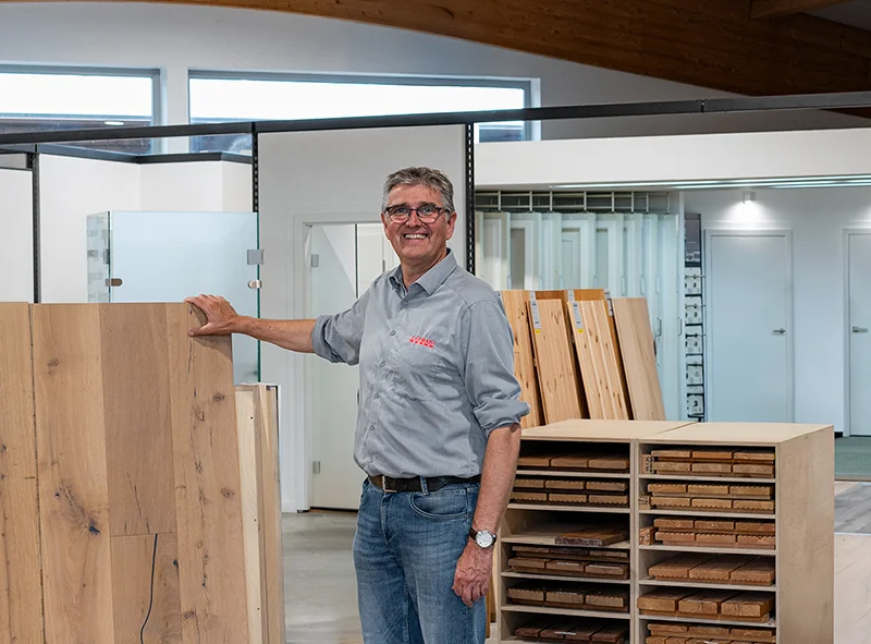 Frank Ramrath in der Bodenausstellung – zeigt einen Parkettboden und heißt Besucher willkommen. Nehmen Sie gerne kontakt zu uns auf!