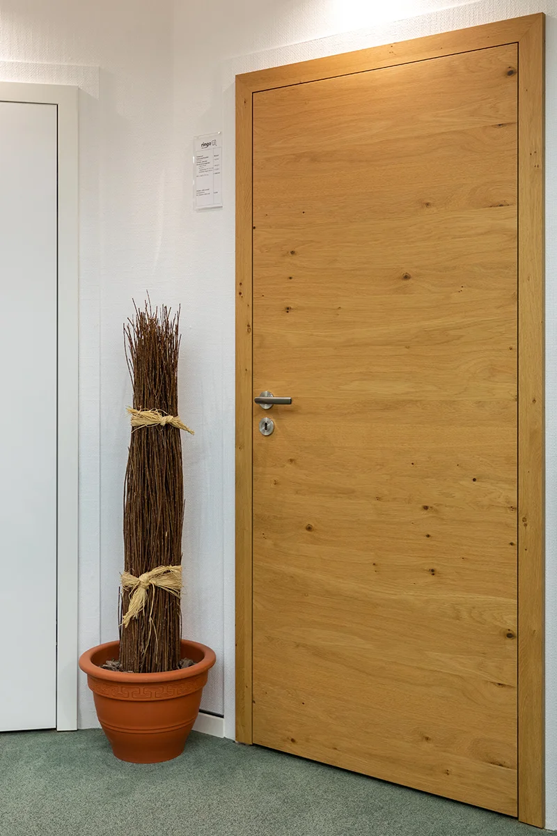 türen - Stumpfeinschlagende Echtholztür ohne sichtbare Falz mit moderner Edelstahl-Drückergarnitur