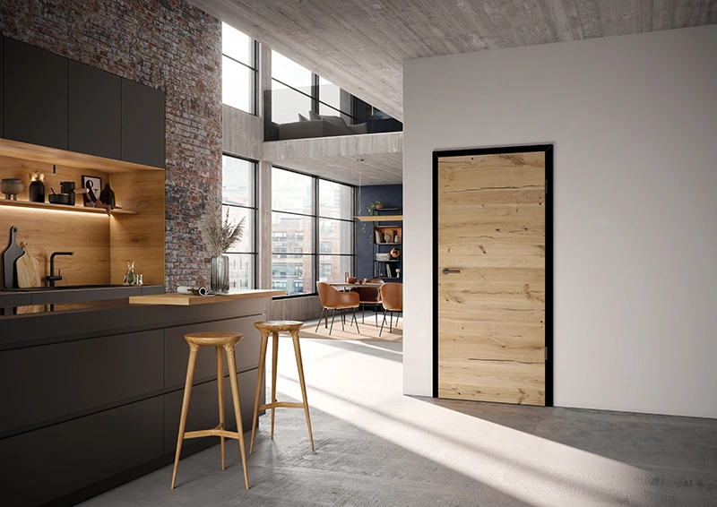 Zimmertür Ringo in Holzoptik mit schwarzer Zarge – Designstatement in der offenen Küche türen - Moderne Türen in markanter Holzoptik mit schwarzer Zarge in offener Loftküche mit Sichtbeton und Backsteinwand